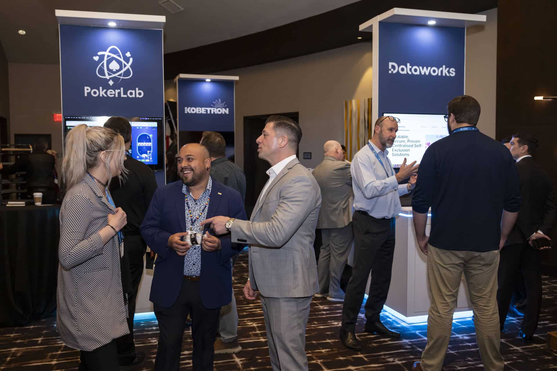 Attendees in professional atire converse with each other in a busy networking area at the Regulators Roundtable conference.